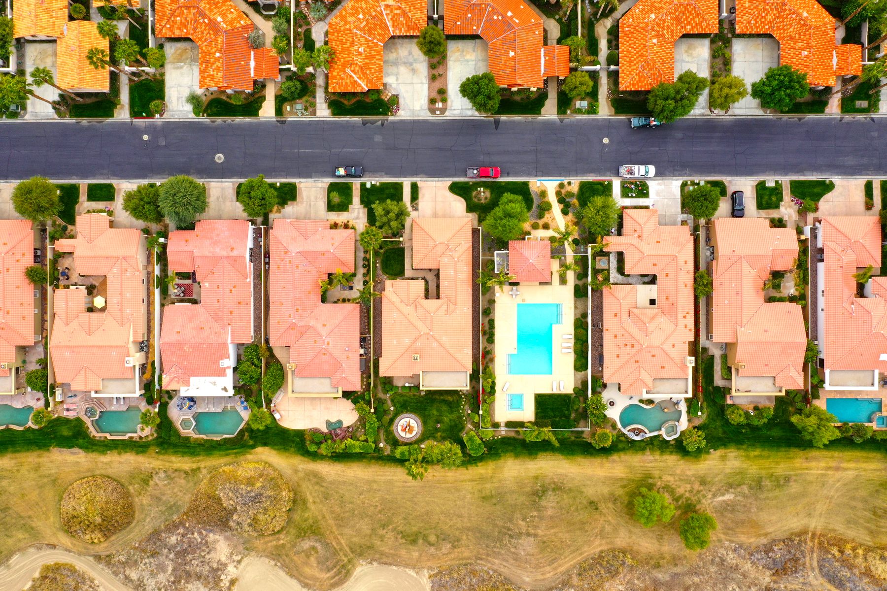 Top-down drone view of La Quinta homes with private pools and desert landscaping