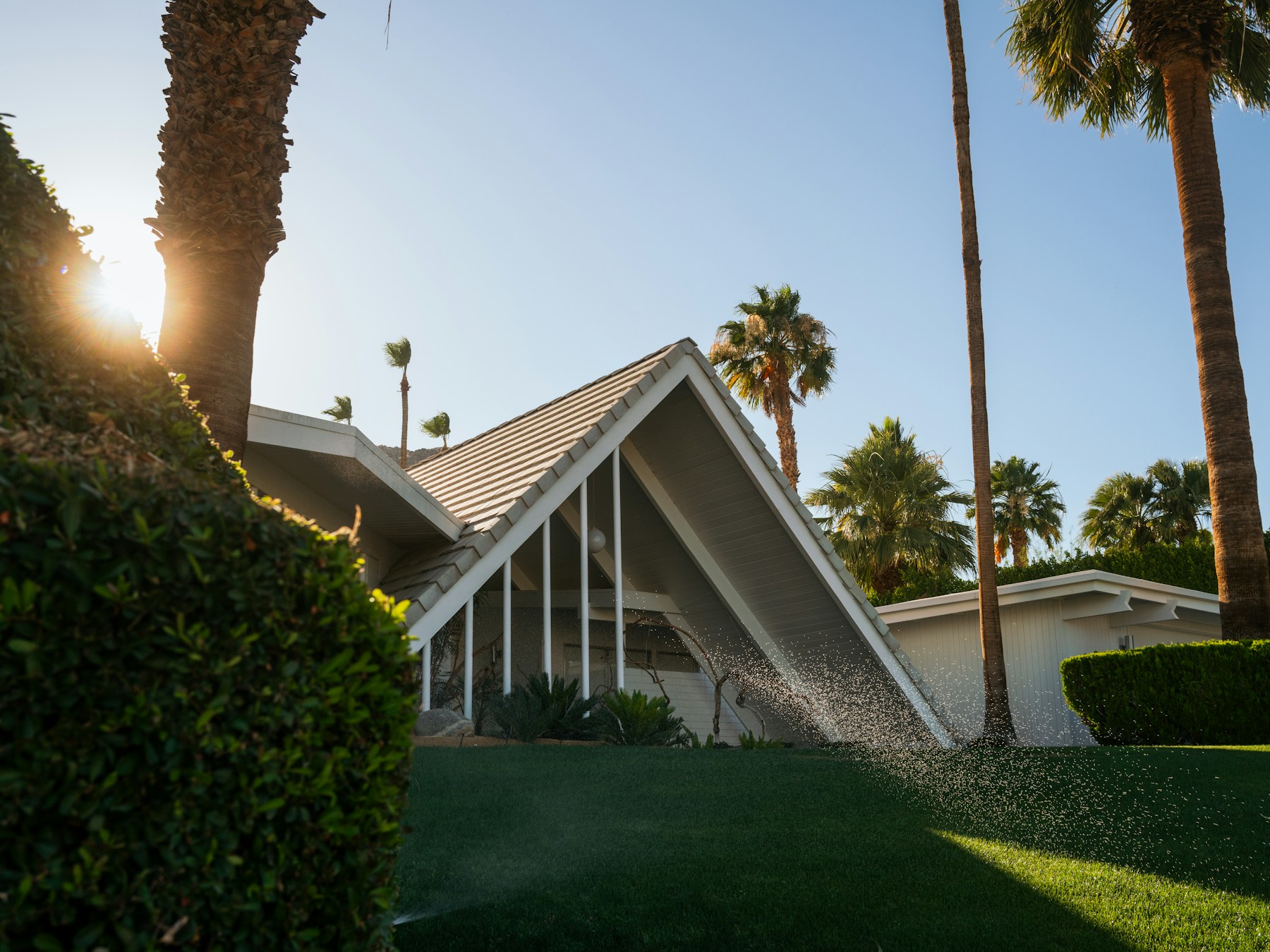 Old Las Palmas midcentury A-frame residence framed by palms and afternoon light