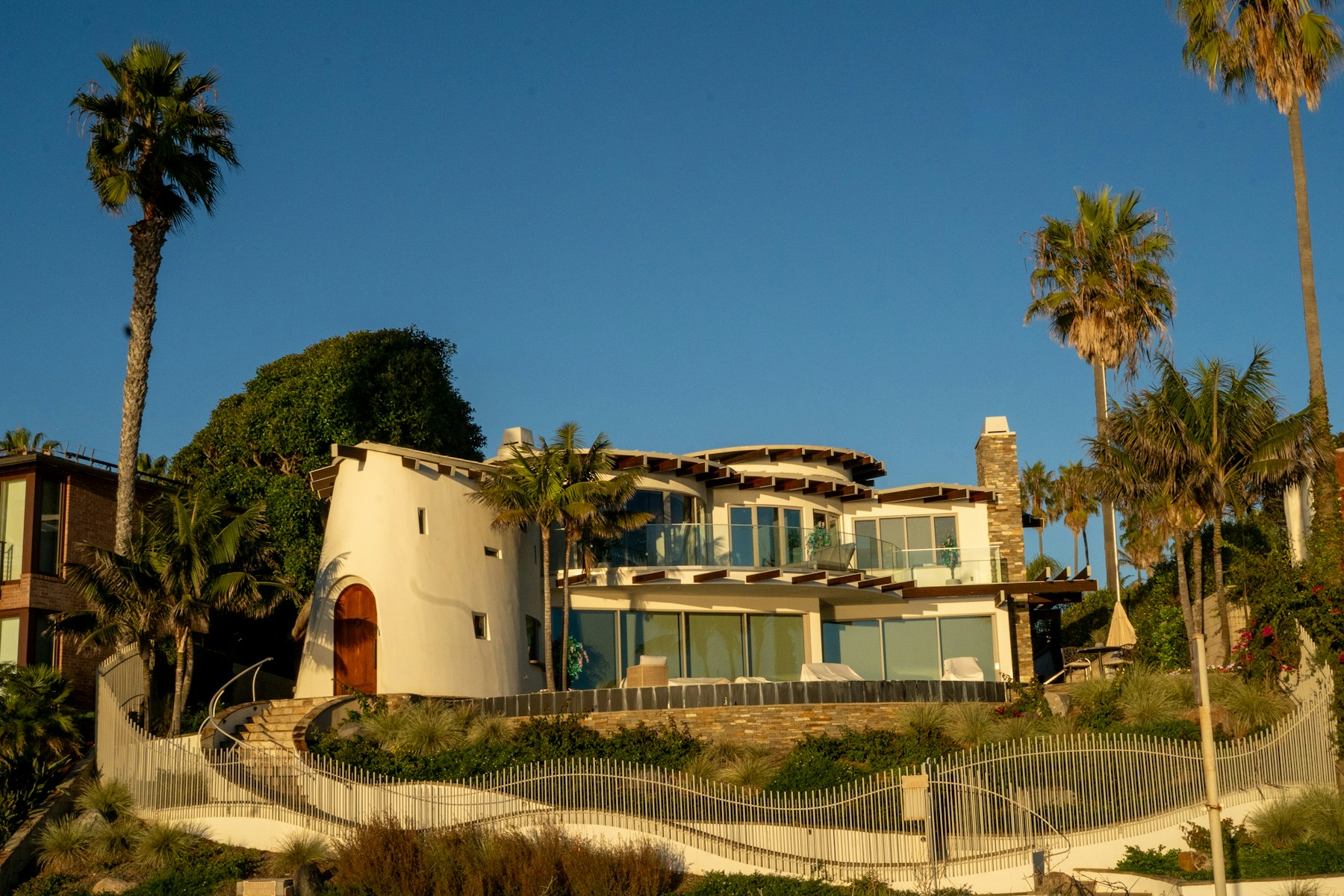 Contemporary San Diego coastal residence with palms, terraces, and warm evening light