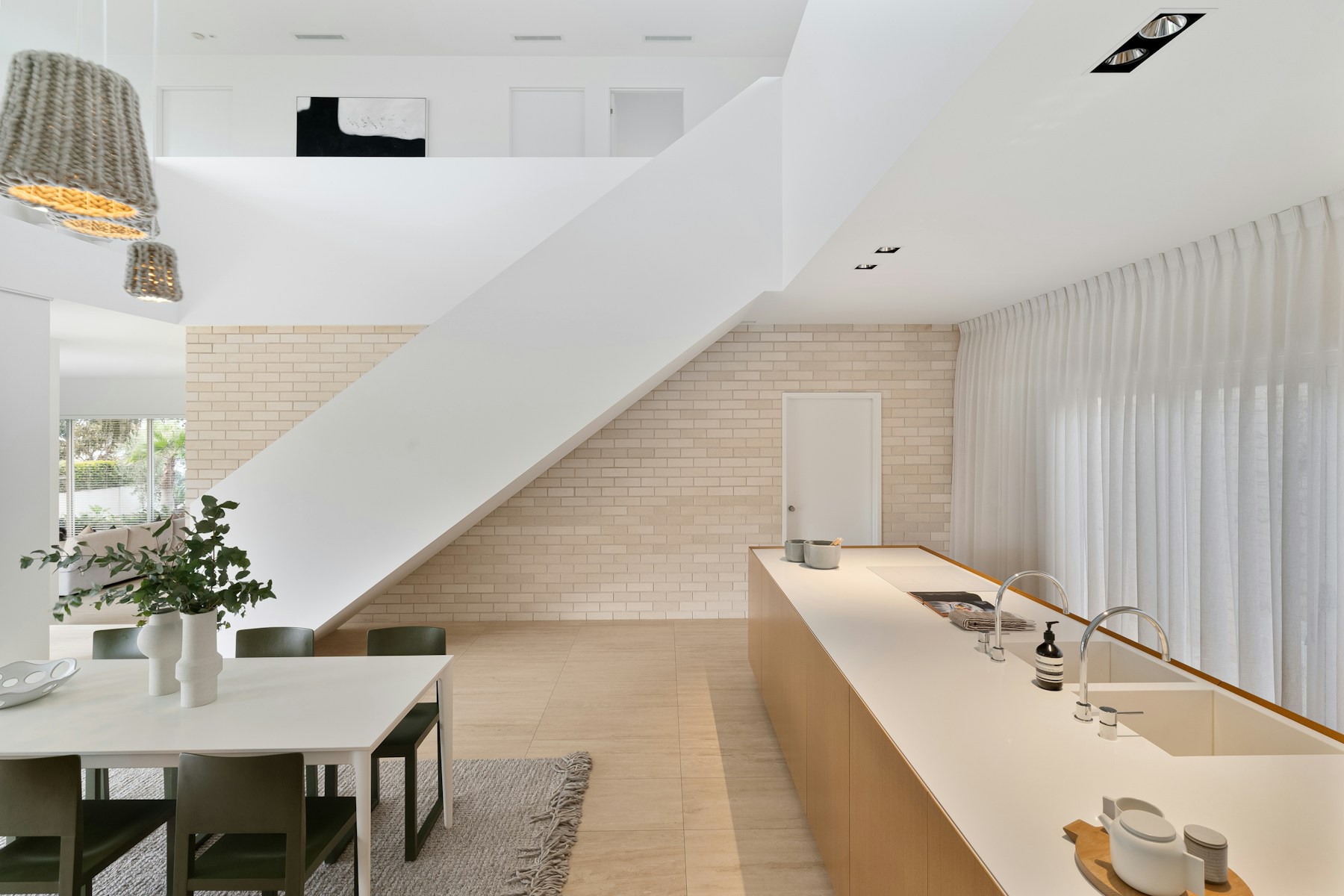 Minimal modern kitchen and dining area with sculptural architecture and natural materials