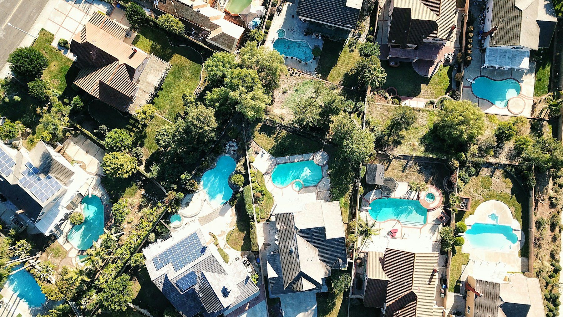 Top-down aerial view of Los Angeles homes and backyard swimming pools