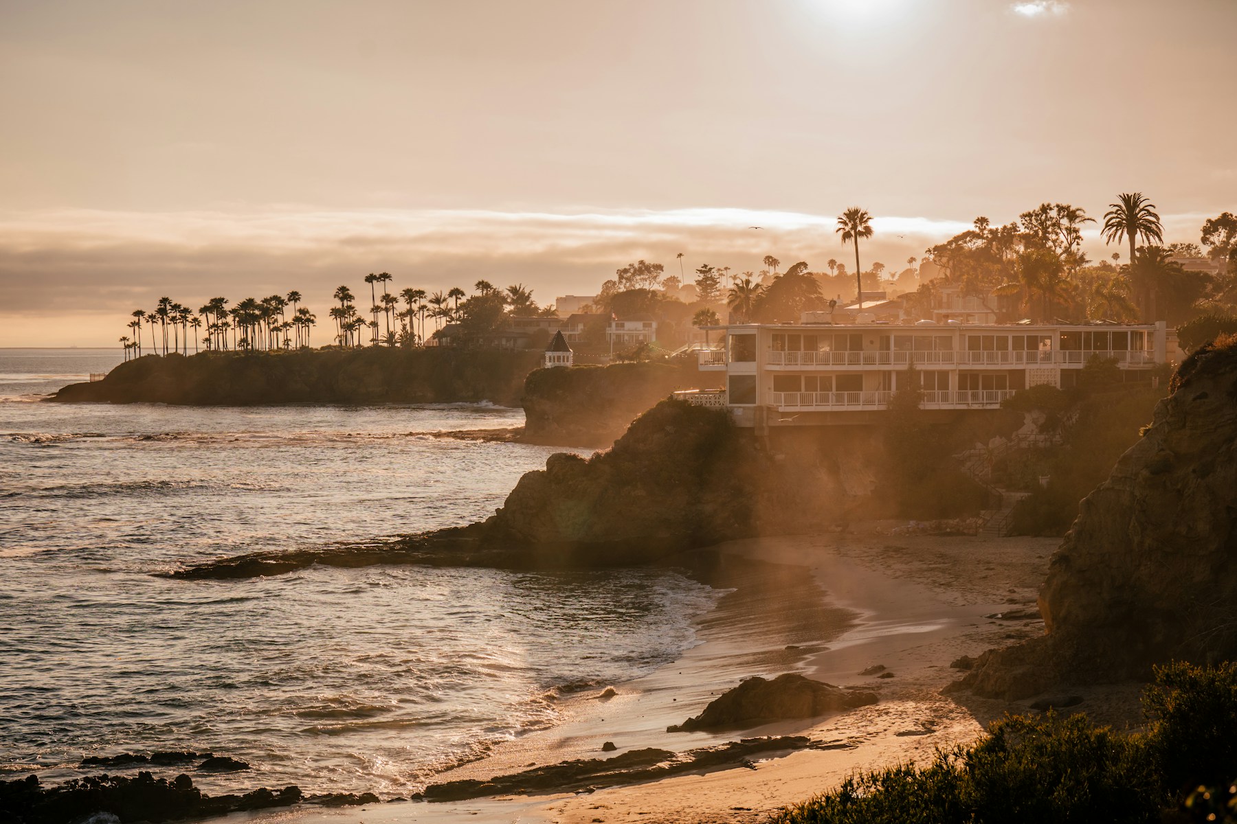 Coastal residences above a Laguna Beach cove at golden hour